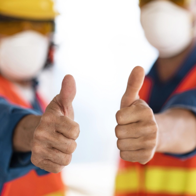 colleagues-with-safety-equipment-showing-ok-sign